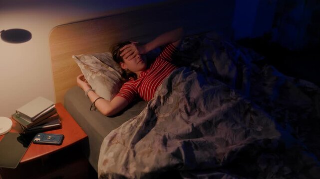 Frustrated young girl turning face down in bed struggling with sleep disorder