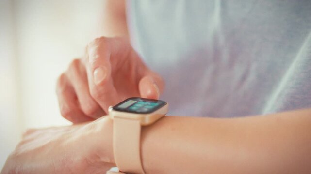 In a close-up, a girl studies her fitness watch, reading workout stats and heart-rate data. Using wearable technology, she tracks calories and activity to fine-tune her training session