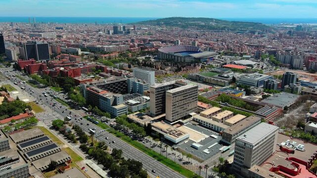 4K aerial drone footage over Barcelona, Spain, Camp Nou stadium, university campus, Avinguda Diagonal, and Mediterranean Sea on the horizon, Les Corts district, Catalonia.
