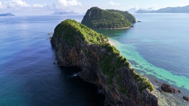 Pull-away tilt-up shot revealing the cliffside of Camago Island at Liminangcong, Philippines