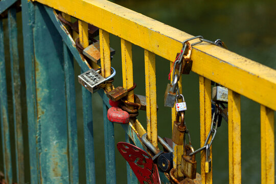 Love locks bridge. Romantic padlocks railing. Couple symbol tradition. Heart shaped decoration. Rusty lock collection. Relationship memory spot. Lovers bridge detail. Metal fence romance. Commitment