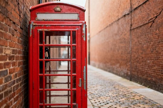 Vintage Red Phone Booth in Cobblestone Alley