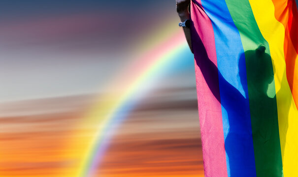person holding rainbow flag for prode month