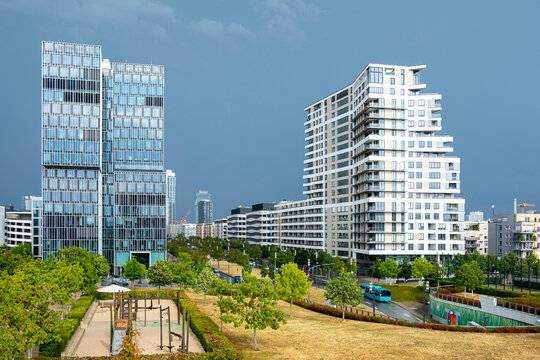 Modern buildings rise beyond a green garden in Frankfurt, where urban architecture, skyline forms, residential facade and landscape shape the exterior