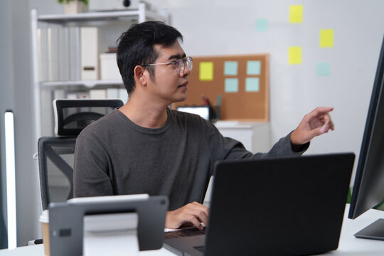 Focused Developer Working on Computer in Office Environment Enhancing Productivity