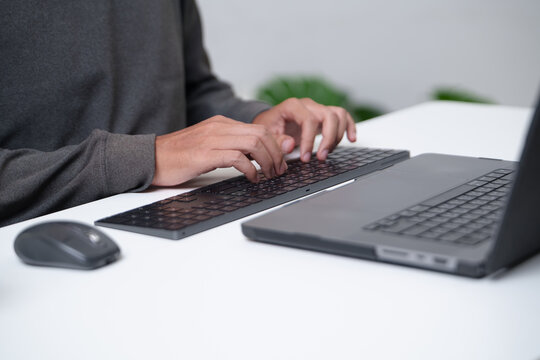 Focused programmer typing on a laptop in a workspace environment conducive to productivity
