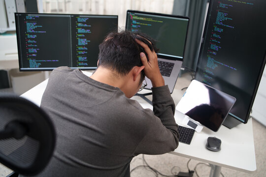 Overwhelmed Programmer Struggling with Code Debugging at a Multiscreen Setup and Troubleshooting