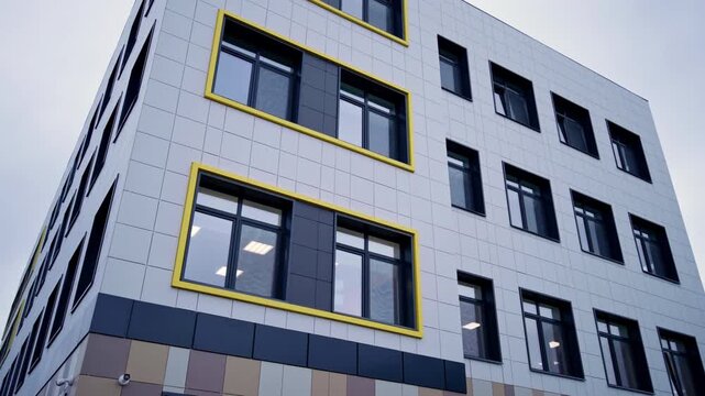 Structured window grids contrast nicely with crisp clean wall paneling system. Multi-toned brown and tan pattern wraps ground floor base