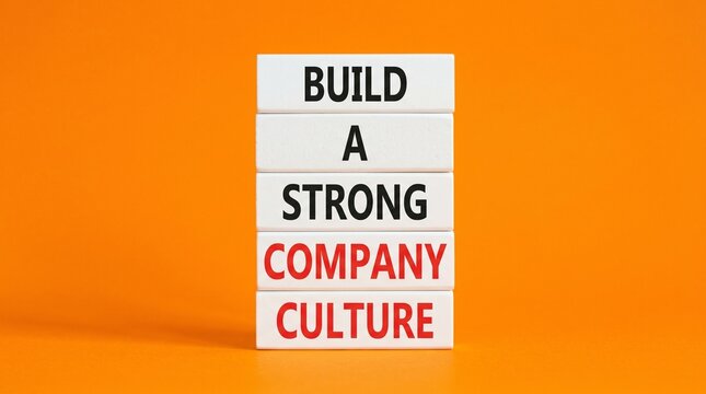 Stacked lettered cubes against a vivid orange backdrop spell out Build a Strong Company Culture, presenting a simple corporate motivation theme with generous negative space.