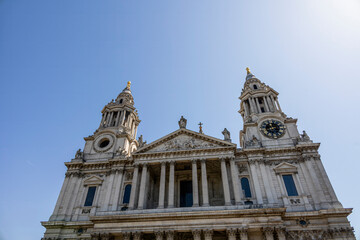 Fototapeta premium Stunning view of St. Paul's Cathedral captured from Ludgate Hill in London, showcasing its iconic architecture against a clear blue sky.