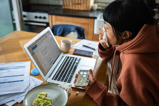Sick woman working from home in kitchen