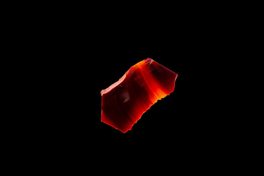 A piece of translucent brown agate natural mineral stone isolated on black background