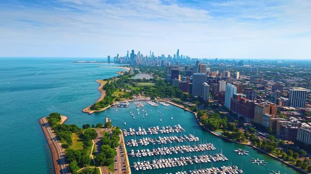 Descending over the shore of Lake Michigan near the harbor with vessels. Waterscape and Chicago cityscape from drone footage.