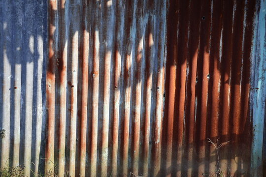 An old and rusty zinc sheet wall. Vintage style metal sheet roof texture. Pattern of old metal sheet. Rusting metal or siding. Corrosion of galvanized. Background and texture in retro concept