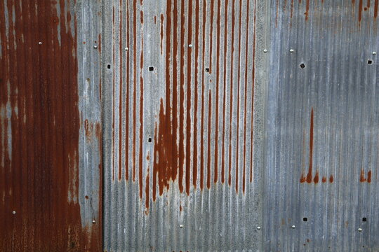 An old and rusty zinc sheet wall. Vintage style metal sheet roof texture. Pattern of old metal sheet. Rusting metal or siding. Corrosion of galvanized. Background and texture in retro concept