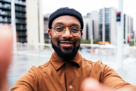 Smiling man wearing eyeglasses taking selfie