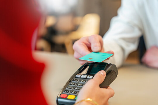 Customer paying with contactless credit card at terminal
