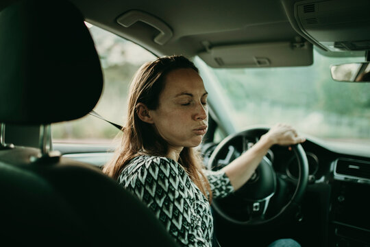 Mid adult woman breething deeply in car