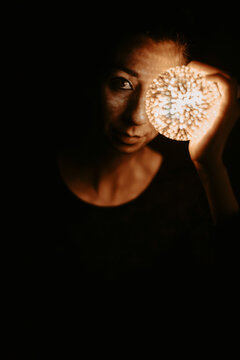 Dark moody portrait holding a glowing light orb