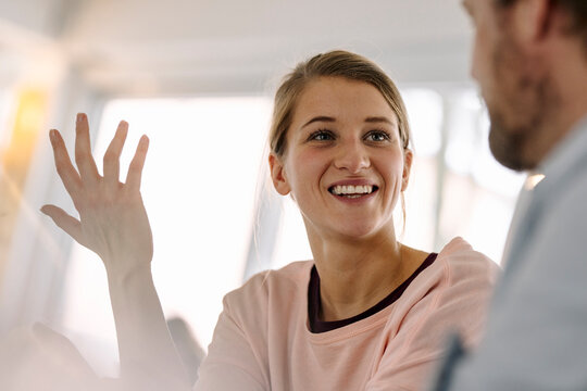 Portrait of smiling young woman talking to man
