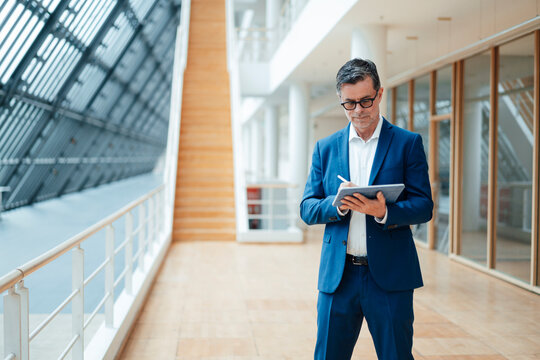 Businessman using tablet PC standing at office