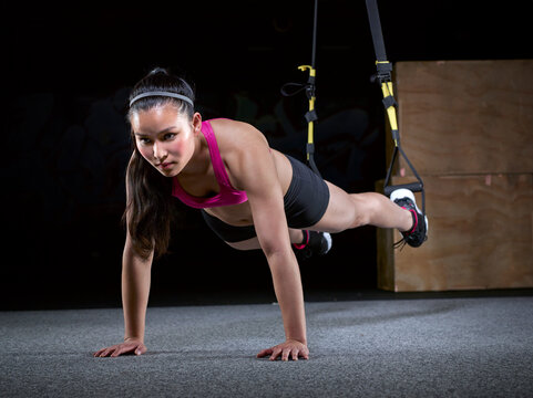 Young woman doing suspension training