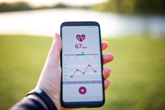 Woman holding smartphone, using fitness app