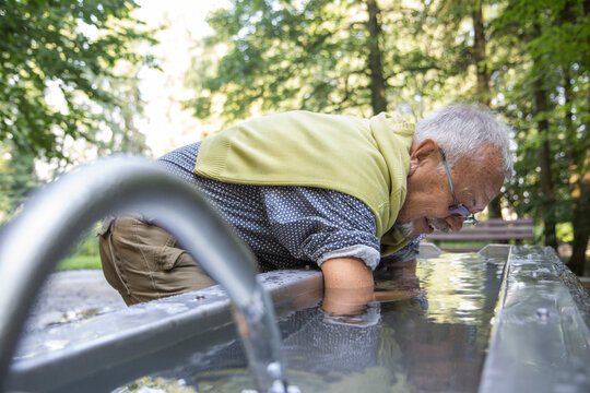 Senior man during Kneipp cure, Kneipp basin, cold arm bath