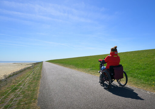 Wheelchair user on coastal path at Terschelling waddensea island