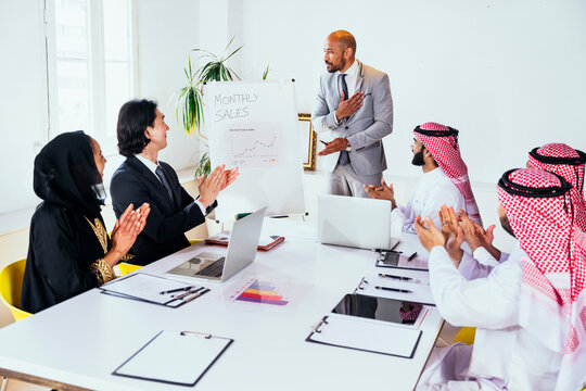 Global business team clapping during office presentation in Riyadh