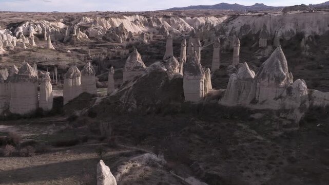 Aerial view of the iconic fairy chimneys of Love Valley in Cappadocia, Turkey. Unique rock formations sculpted by erosion rise from the volcanic landscape.