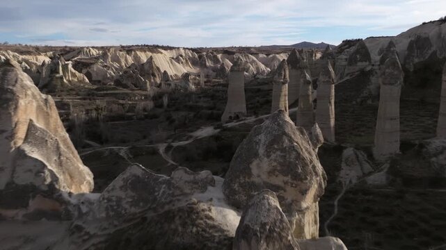 Aerial view of the iconic fairy chimneys of Love Valley in Cappadocia, Turkey. Unique rock formations sculpted by erosion rise from the volcanic landscape.