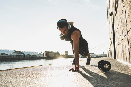 Fit athlete doing push ups at the river