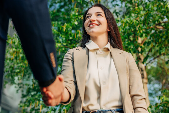 Manager in suit smiling during outdoor handshake for job hiring