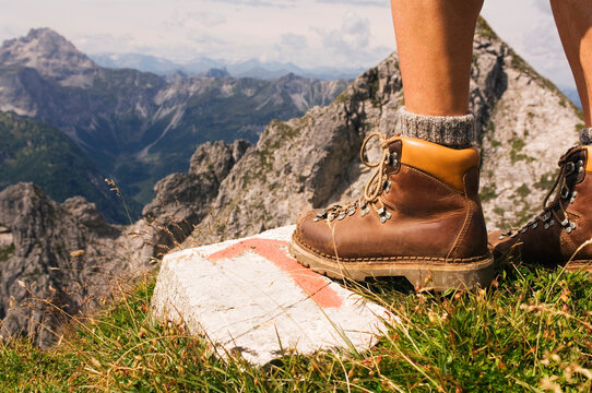 Hiking boot on rock with trail marker in Salzburger Land