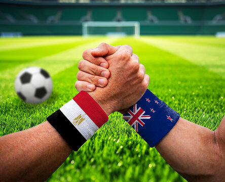 Egypt and New Zealand soccer players showing friendship on green field
