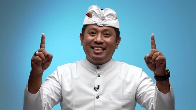 Balinese man in traditional Udeng uses a microphone to deliver an engaging cultural presentation, sharing insights into Balinese heritage, traditions, and spirituality for education and understanding.