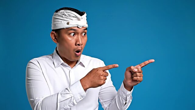 Astonished Balinese man pointing to a surprising digital announcement or special offer. Ideal for marketing, promotions, revealing new products, important news, and exciting deals with a cultural...