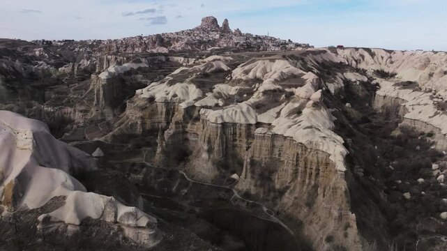 Drone view of Ortahisar Castle towering above the historic town of Ortahisar in Cappadocia, Turkey. A remarkable example of rock-carved architecture.