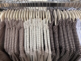 Shirts on hangers in row showing different plaid patterns in neutral tones, suitable for background © dvoevnore