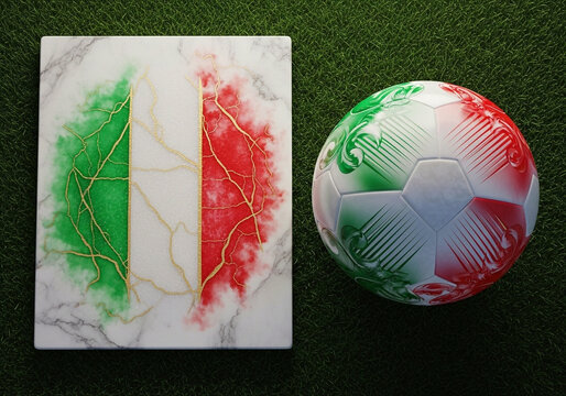A soccer ball and marble slab with Italian flag colors on green grass