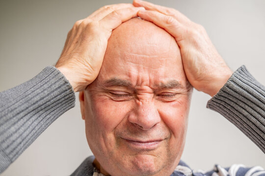 Close up senior man 60-65 years old with hand, expressing stress, headache, or frustration, desperate individuals behind, concept mental human health, Emotional breakdown