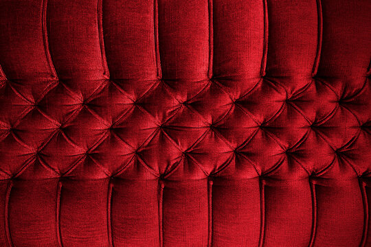 Close-up of red sofa upholstery. Red sofa upholstered with Capitone quilting.