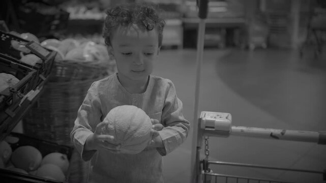 Toddler Reaching for Cabbage in Supermarket Produce Aisle