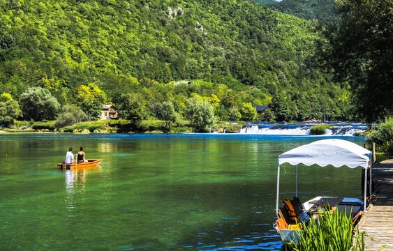 Tourist boats on the Una River with waterfalls and green forest near Bihac Bosnia and Herzegovina