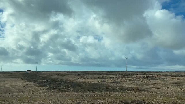 Time-lapse video captured while travelling around a volcanic mountain and coast in Fuerteventura, Canary Islands, Spain. Dramatic clouds, rugged terrain and arid landscapes 