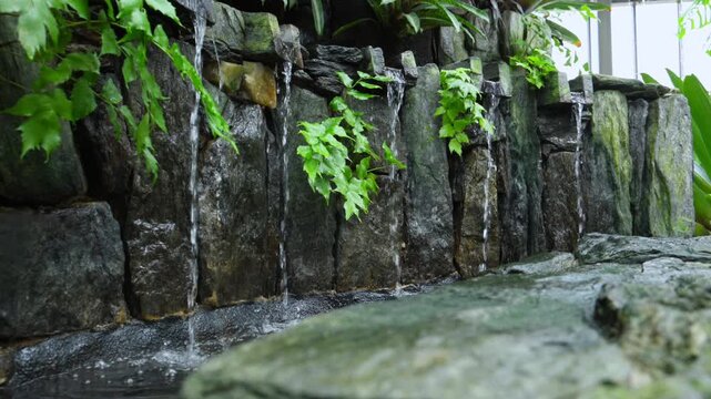 Small artificial waterfalls. The water feature consists of numerous small streams cascading down intricately arranged stone channels.
