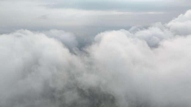 Aerial view flying through clouds revealing mountain village