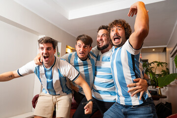 Grupo de amigos argentinos celebrando un gol mientras ven un partido de fútbol © Matias Lee