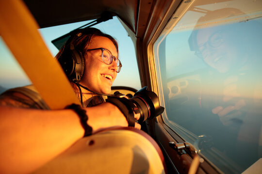 Flying a small plane over the sunset sky with a happy passenger